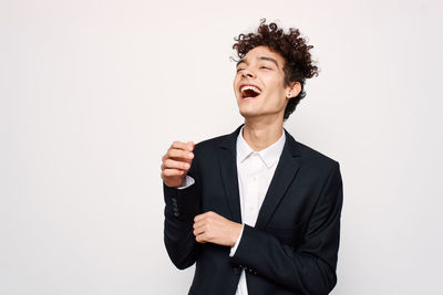 Smiling young man standing against white background