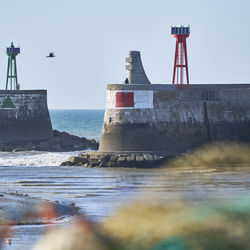 Lighthouse by sea against sky