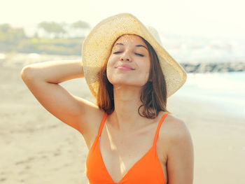 Close-up of woman wearing hat while standing at beach