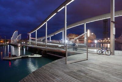 Bridge over river against sky in city at night