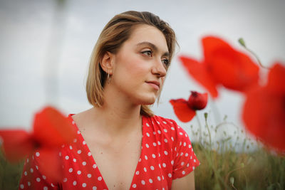 Portrait of beautiful woman with red flower