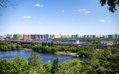 Buildings by river against sky