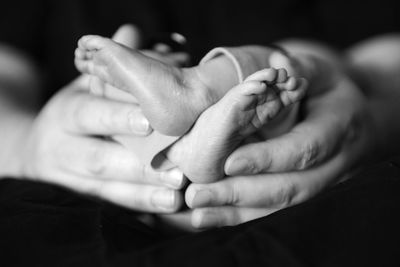 Close-up of hands holding baby's feet