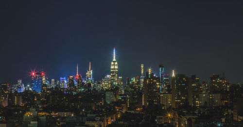 Illuminated buildings against sky at night