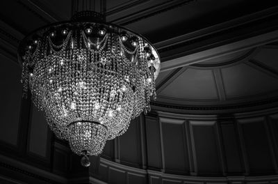 Low angle view of illuminated chandelier hanging in building