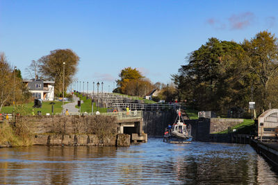 Scenic view of river by buildings against sky