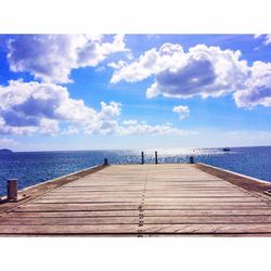 Jetty in sea against sky on sunny day