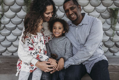 Lifestyle image of happy family hugging each other and smiling