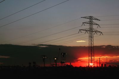 Silhouette electricity pylon against sky during sunset