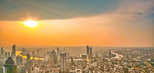 Aerial view of modern buildings against sky during sunset