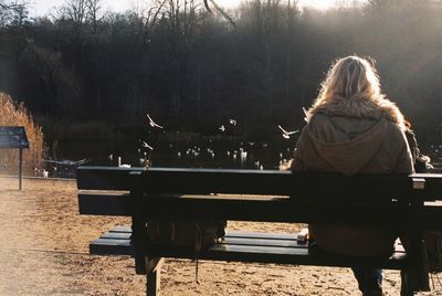Rear view of woman sitting against sky
