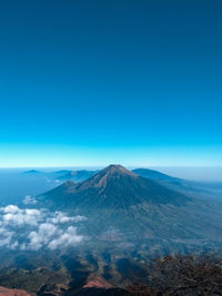 Scenic view of mountains against blue sky