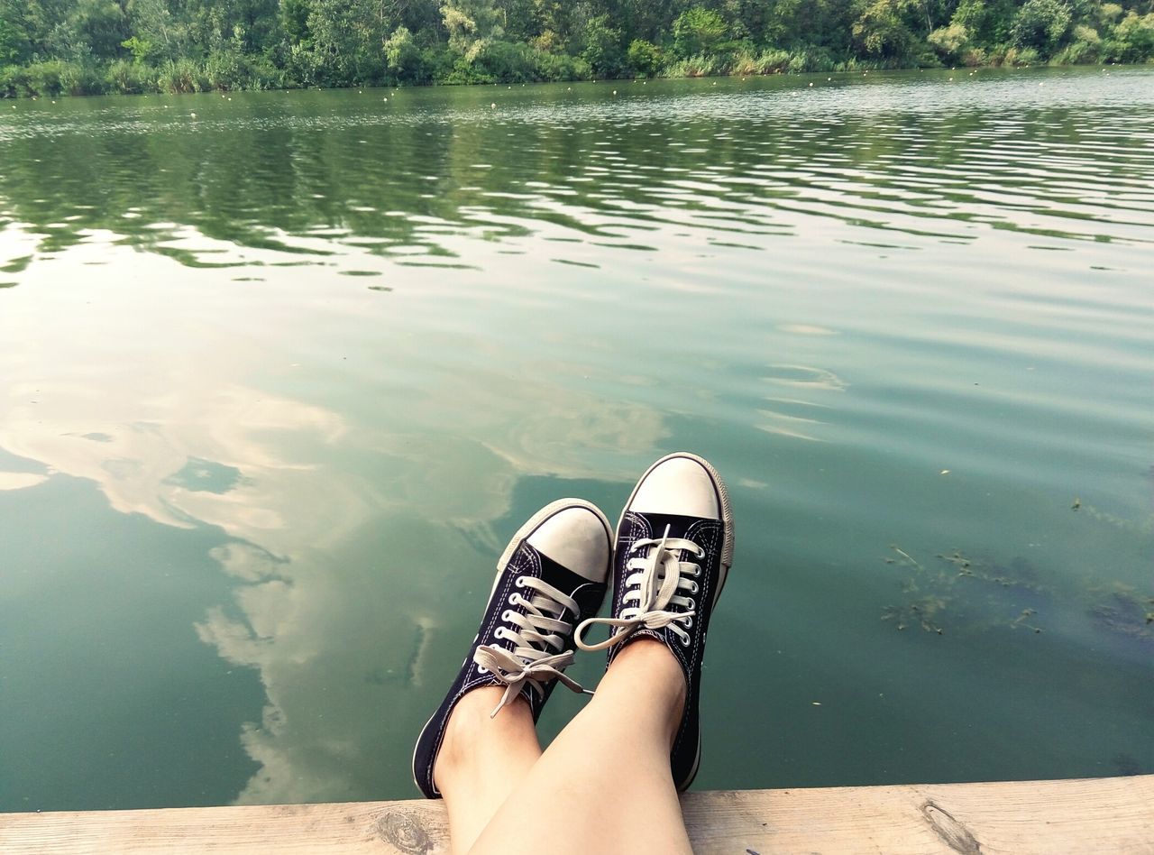 low section, person, relaxation, water, lake, sitting, personal perspective, lifestyles, young women, footwear, vacations, tranquility, young adult, tourist, casual clothing, carefree, day, resting, tourism, outdoors, weekend activities, non-urban scene