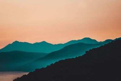 Scenic view of silhouette mountains against sky during sunset