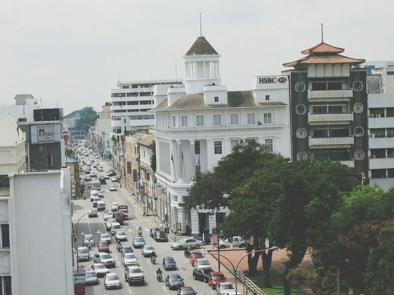 building exterior, architecture, built structure, car, land vehicle, city, transportation, street, mode of transport, incidental people, city life, road, building, residential building, city street, residential structure, tree, day, travel, clear sky