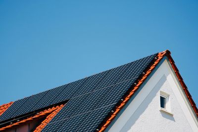 Low angle view of roof of building against blue sky