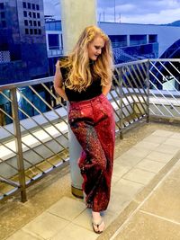 Young woman standing against railing