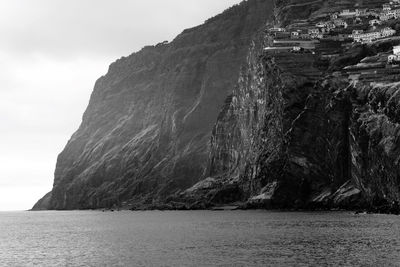 Rock formations by sea against sky