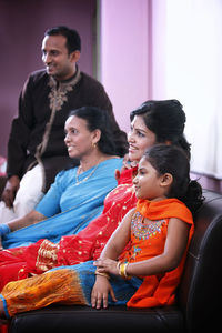 Family sitting on sofa at home