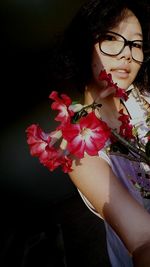 Midsection of woman holding red flowering plant