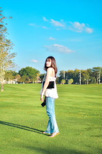 Young woman standing on grassy field