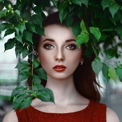 Close-up portrait of a young woman with leaves