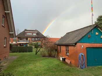 Scenic view of rainbow over buildings against sky