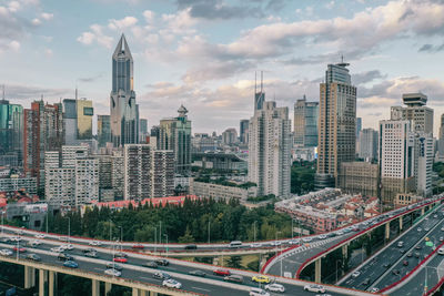 High angle view of buildings in city against cloudy sky