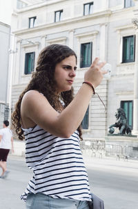 Portrait of young woman standing in park