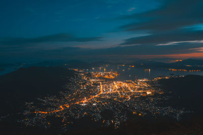 High angle view of illuminated cityscape against sky at night