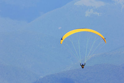 High angle view of man paragliding above mountains