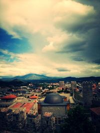 Cityscape against cloudy sky