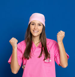 Portrait of a smiling young woman against blue background