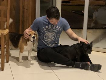 Man with dog sitting on tiled floor