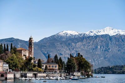 Scenic view of buildings by mountains against clear sky