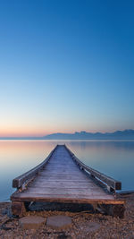 Pier over lake against blue sky