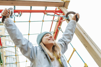 Happy girl playing on playground under sky