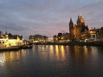 Reflection of illuminated buildings in river at dusk