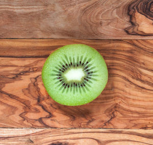 Round slice of kiwi on wooden board