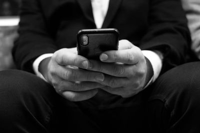 Midsection of man using mobile phone