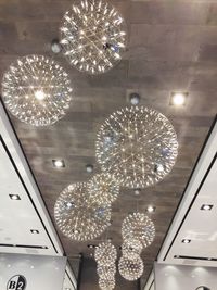 Low angle view of illuminated chandelier hanging from ceiling