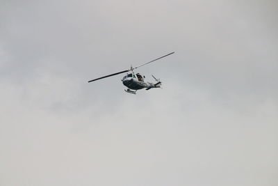 Low angle view of helicopter flying against sky