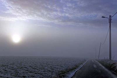 Road by street against sky during foggy weather