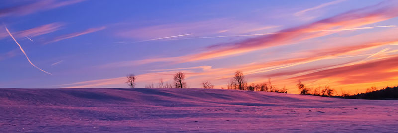 Scenic view of snow covered landscape against sky during sunset