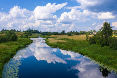 Landscape with beautiful cumulus clouds reflecting in the teza river, ivanovo region on a summer day