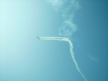 Low angle view of vapor trail against clear blue sky