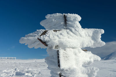 Close-up of snow against clear blue sky