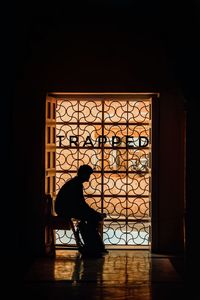 Man sitting on chair by window at home