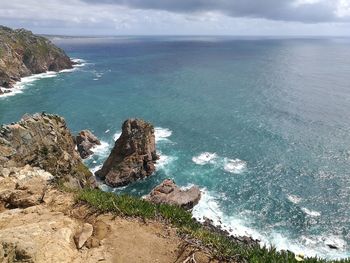 High angle view of rock formation by sea against sky