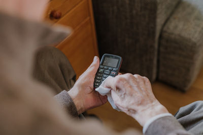 Midsection of man holding mobile phone